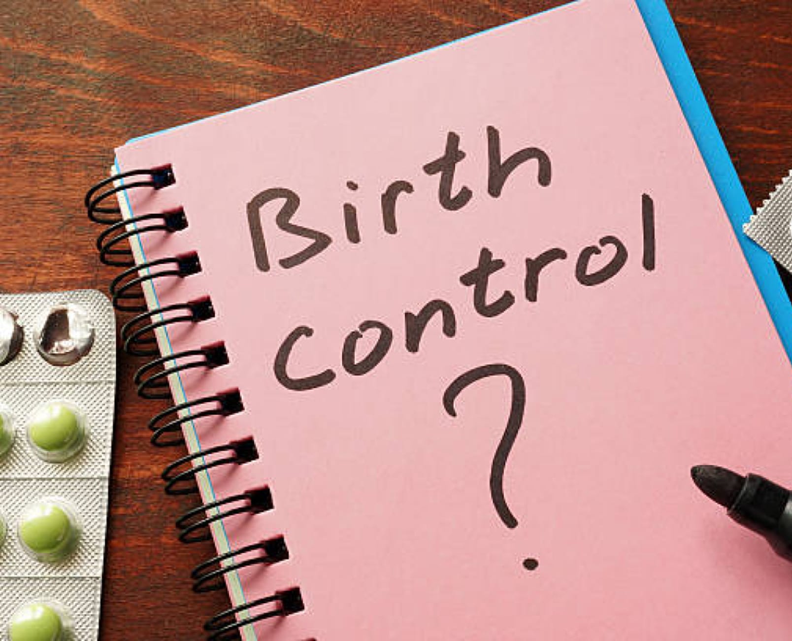pink notebook with "birth control?" written on it in black marker